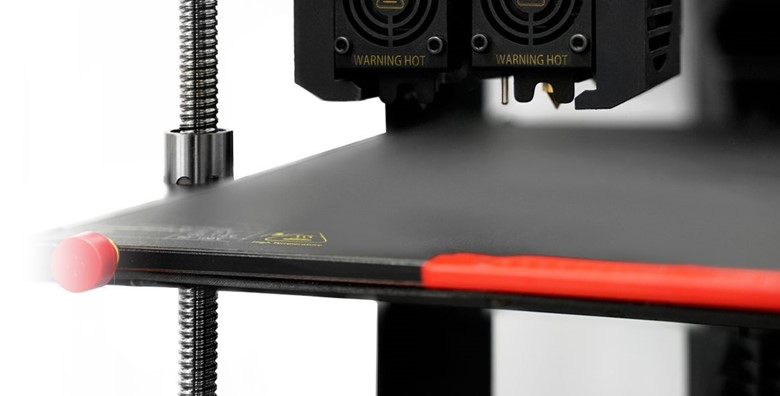 A close-up view of a Raise3D printer bed and dual extruder head